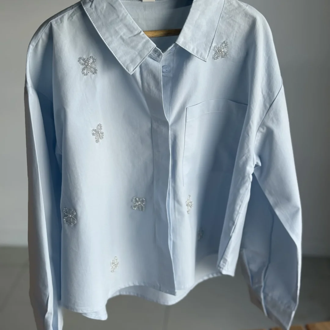 CAMISA BOW CELESTE. LÍNEA IMPORTADA